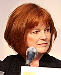 A color headshot of Blair Brown at a microphone