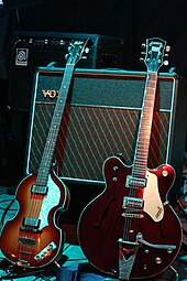 A Höfner "violin" bass guitar and Gretsch Country Gentleman guitar, models played by McCartney and Harrison, respectively; the Vox AC30 amplifier behind them is the model the Beatles used during performances in the early 1960s