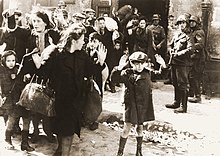 Iconic photograph of Jewish women and children being herded out of a building