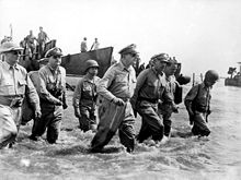 Douglas MacArthur, Sergio Osmeña, and Osmeña's staff wading ashore in knee-deep water