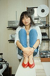 Picture of an Asian woman in her thirties sitting on a table