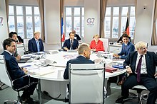 Trump and other G7 leaders sit at a conference table