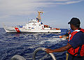 A boatswain's mate keeps watch on a small boat as it heads for the USCGC Chandeleur in 2008