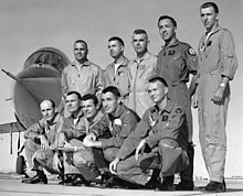 Two rows of men in front of a jet