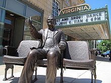 An image of a bronze statue of Roger Ebert outside of a movie theater.