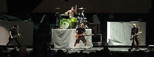 +44 performing in 2006. From left to right: Craig Fairbaugh, Travis Barker, Mark Hoppus, and Shane Gallagher.