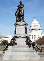A black statue of Garfield atop an elaborate pillar. The United States Capitol rotunda is visible in the background.