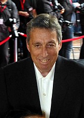 Photograph of director Ivan Reitman at a red carpet event with photographers behind him