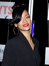 Rihanna wearing a black top and hoop earrings