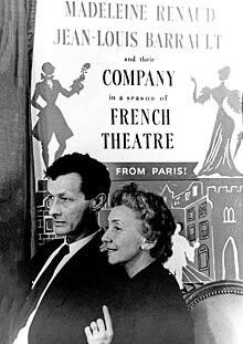 Barrault and Renaud standing in front of a poster for their company