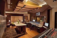 A photo of the control room to Jungle City Studios, featuring recording equipment, desks, and other furnishings