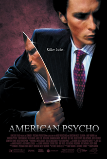 A man in a business suit, his face is reflected in the large knife he is holding