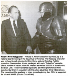 Newspaper photo of former US president Richard Nixon shaking hands with someone dressed as RoboCop