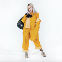 Eilish is seen holding a garbage bag, wearing all yellow.