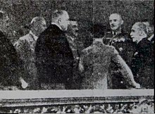 blurred and doctored press photograph showing a group in a box in a concert hall