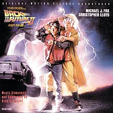 Michael J. Fox and Christopher Lloyd stepping out of a partially-visible DeLorean vehicle, looking astonishingly at their wristwatches. The Back to the Future Part II logo is on the top left of the cover.