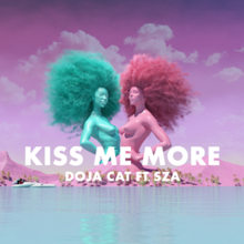 Two mannequins that resemble SZA and Doja Cat standing side by side, colored teal and pink, respectively. The mannequins are standing behind a pink mountain range, with a large body of water located in front. The title "KISS ME MORE" is printed in white text on the center of the cover art, with the artists' names in a smaller font located below it.