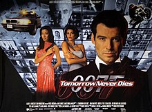 A man wearing a tuxedo holds a gun. On his sides are a white woman in a white dress and an Asian woman in a red, sparkling dress holding a gun. On the background are monitors with scenes of the film, with three at the top showing a man wearing glasses holding a baton. On the bottom of the screen are two images of the 007 logo under the title "Tomorrow Never Dies" and the film credits.
