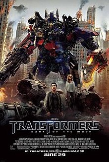 The poster depicts Optimus Prime, standing with a blade in his left arm, and a rifle in his right arm. There is also a young couple standing below the Transformer, and just where the 3 are standing, there is also a crash-landed Decepticon fighter. Behind the Transformer and the couple, there is a war-torn city of Chicago, with Decepticon battleships surrounding it. The film title and credits are on the bottom of the poster.