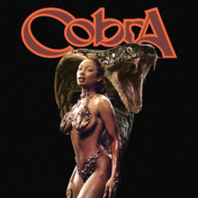 Megan Thee Stallion standing in front of a large cobra, wearing a metallic bikini and pasties.