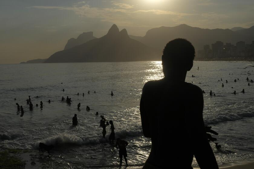 People cool off in the waters of Arpoador beach amid a heat wave, in Rio de Janeiro, Brazil, Wednesday, March 20, 2024. (AP Photo/Silvia Izquierdo)