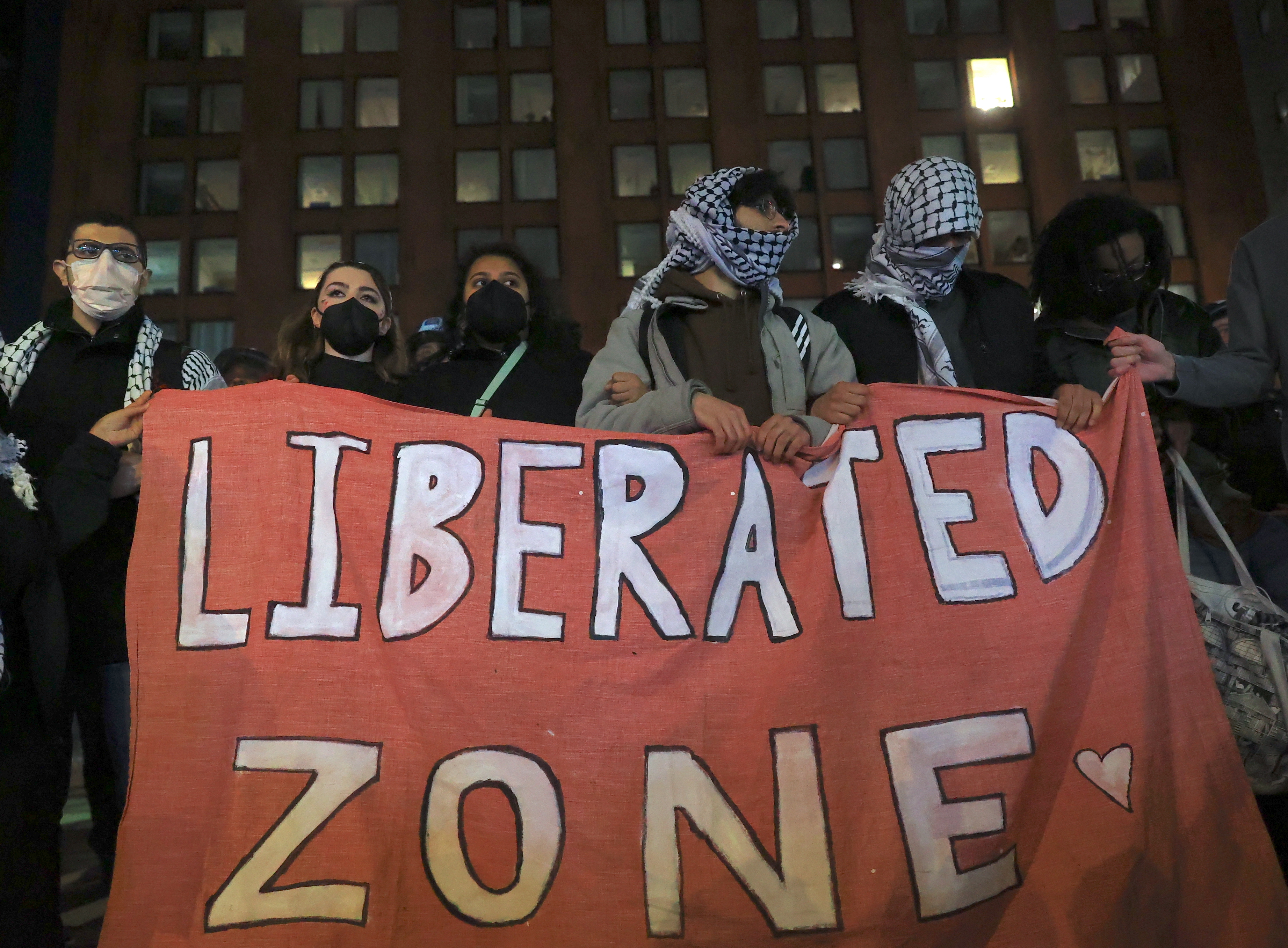 Pro-Palestinian protesters holding a sign that says “Liberated Zone” in New York.