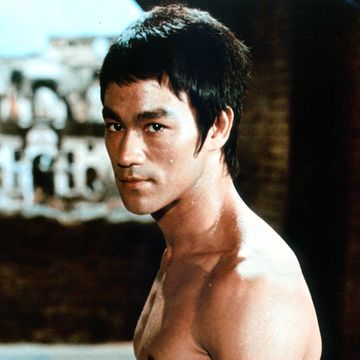 actor bruce lee looking to his left toward a camera