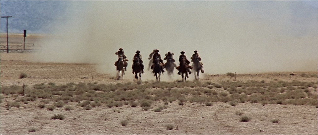 screenshot from Once Upon a Time in the West where 6 men on horseback are galloping toward the camera in a cloud of dust