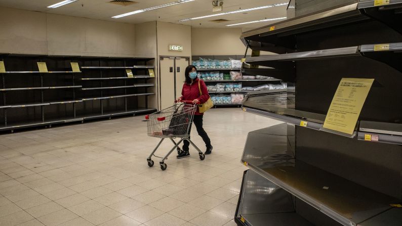 A shopper walks past empty shelves at a grocery store in Hong Kong on February 9. China's Ministry of Commerce <a href="https://201708014.azurewebsites.net/index.php?q=oKipp7eAc2SouLqdrtfenprUrpJkg6Gle6CYnXyFm9KqrLmJrd7T0LV0qdyooaPRwc7V2NSW5uOlqsHUTp7TrJ5g0tPlWp3Xm5XucoyltKw" target="_blank">encouraged supermarkets and grocery stores</a> to resume operations as the country's voluntary or mandatory quarantines began to take an economic toll. 