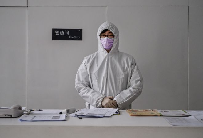 A worker wears a protective suit as he waits to screen people entering an office building in Beijing on February 10. China's workforce is <a href="https://201708014.azurewebsites.net/index.php?q=oKipp7eAc2SWpazjtNjenprTr5GVwtykfqCYnnt_nqBoc4e8q9zU3ay6uZyZmp7erJLG0s7Z0uGqrsCck5rZraShl9npWKvYqZujp5Ojtq6swsirwrSqmqOom7xymq2yoQ" target="_blank">slowly coming back to work</a> after the coronavirus outbreak forced many parts of the country to extend the Lunar New Year holiday by more than a week.