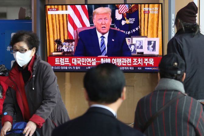 People at a railway station in Seoul, South Korea, watch a live broadcast of US President Donald Trump on March 12. Trump announced that, in an effort to slow the spread of the coronavirus, he would <a href="https://201708014.azurewebsites.net/index.php?q=oKipp7eAc2SouLqdrtfenprUrpJkg6Gle6CZnX2Am-Gmr8HOn8zenqu2tM6ilmLkvdrQ047M4OWwt67liqfaq1-m3sbukKHOpaSlrZKVrLh5tNOmuQ" target="_blank">sharply restrict travel</a> from more than two dozen European countries.
