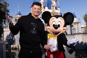 MVP Patrick Mahomes of the Kansas City Chiefs poses with Mickey Mouse in front of Sleeping Beauty Castle at Disneyland Park