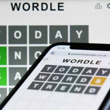 Wordle game displayed on a phone and a laptop screen.