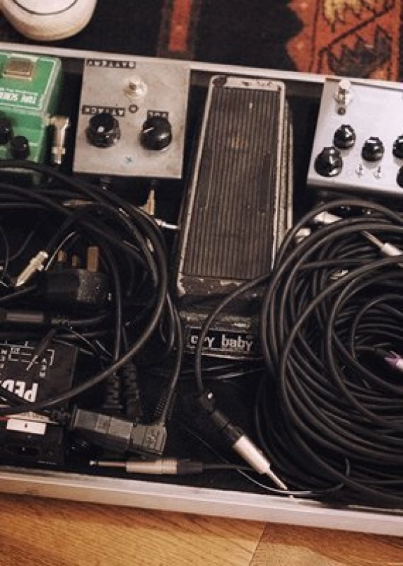 A pedalboard with cables on top