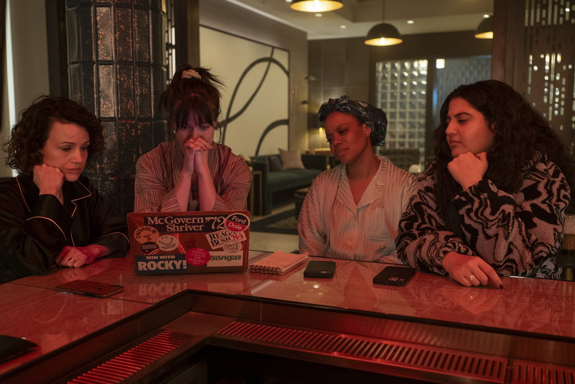 all four main actors from Max's 'Girls on the Bus' gather around a bar table with laptop in Season 1 finale episodic